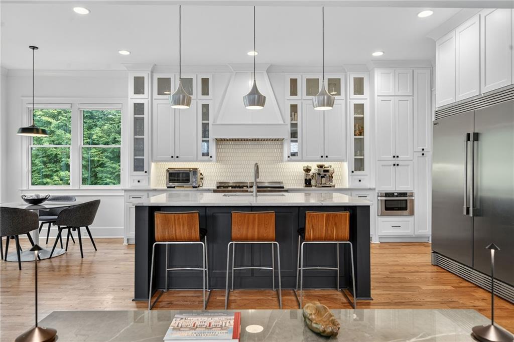 3110 Skyland Drive Northeast Chamblee, GA 30341 - Photo 3 of 43 a kitchen with granite countertop a stove a sink a kitchen island with chairs and refrigerator