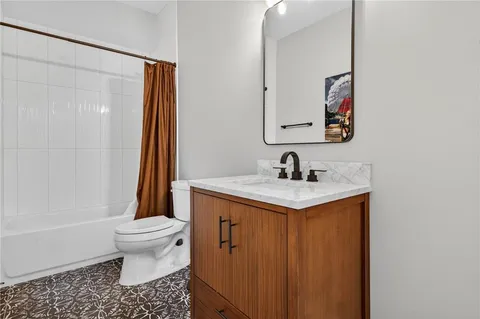 a bathroom with a granite countertop sink toilet and shower