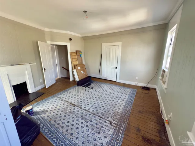 a view of empty room with wooden floor and fireplace