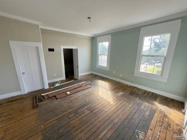 a room with gym equipment and wooden floor