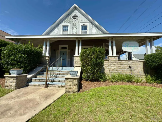 a view of house with garden and tall trees
