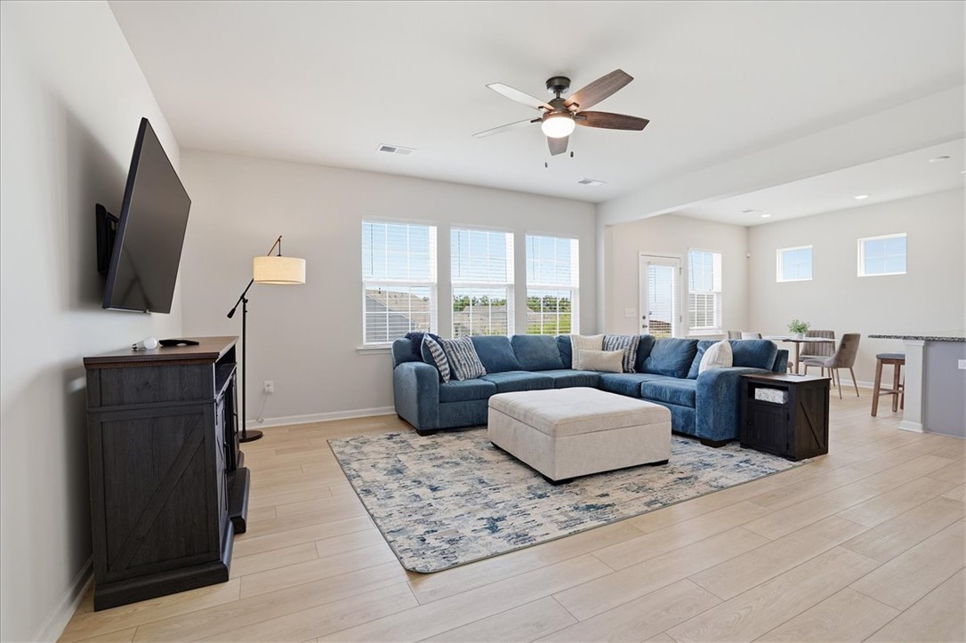 365 Sliding Rock Drive Pendleton, SC 29670 - Photo 7 of 46 A vibrant living space with light-toned flooring seamlessly connects to an open dining area, perfect for entertaining.