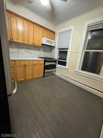 a kitchen with stainless steel appliances granite countertop a refrigerator a stove and a sink with wooden cabinets