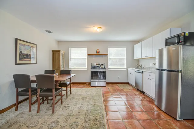 a kitchen with a refrigerator a stove top oven and cabinets