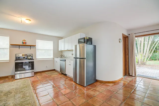 a bedroom with a bed and large windows