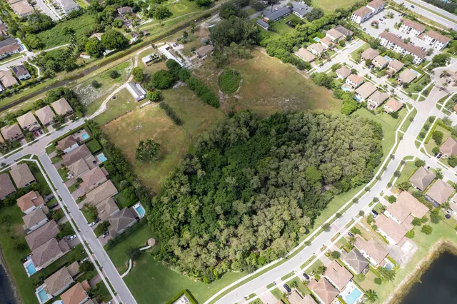 an aerial view of a residential houses with yard