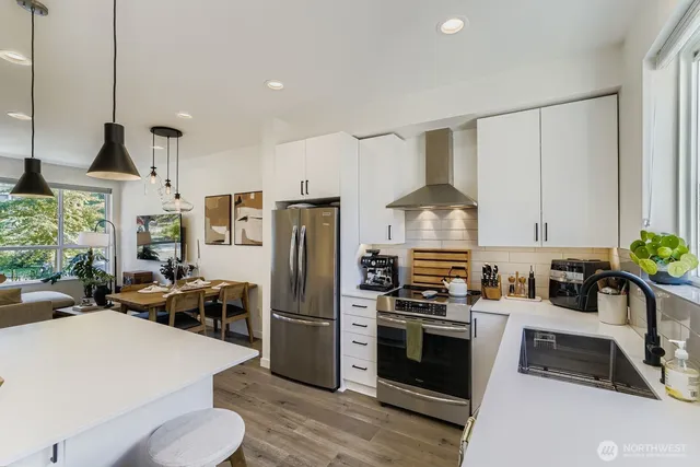 a kitchen with refrigerator a stove a sink and chairs
