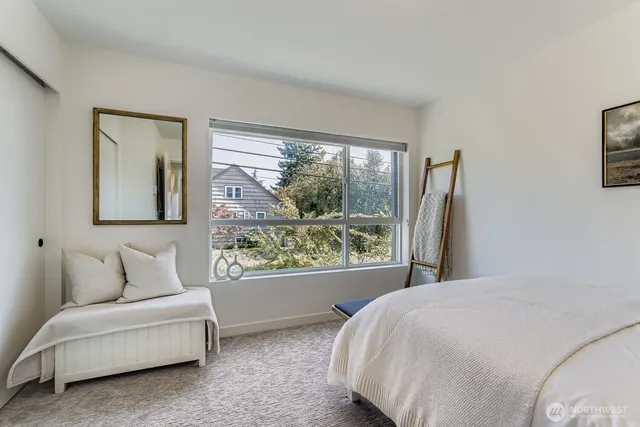 a bedroom with a bed and a large window