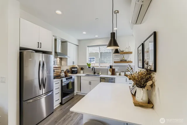 a kitchen with refrigerator and white cabinets
