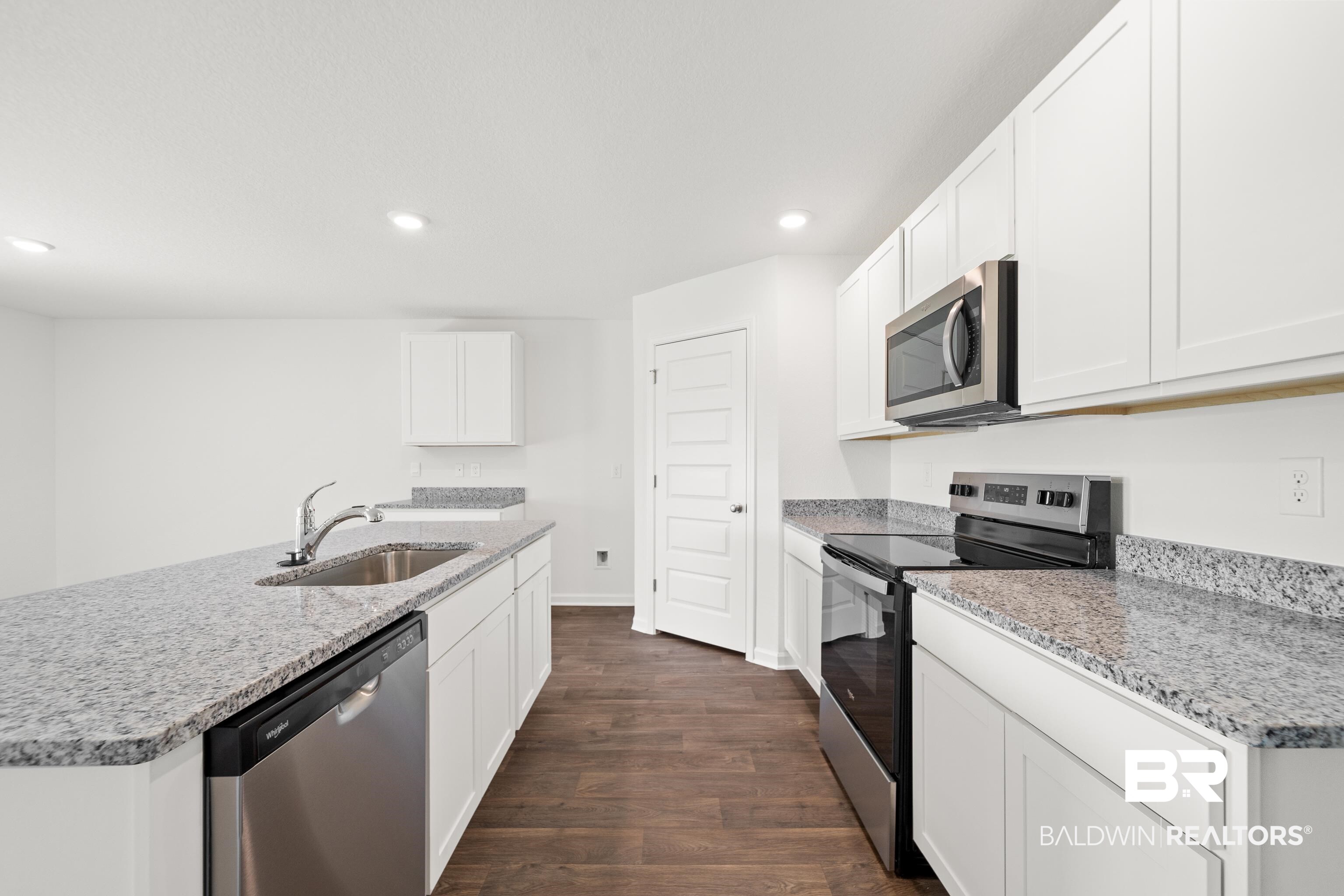 14615 Dayton Circle Foley, AL 36535 - Photo 13 of 27 Bright kitchen featuring white cabinetry, stainless steel appliances, granite countertops, wood-finish flooring, and recessed lighting