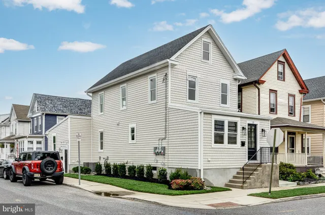 a front view of a house with a garden and parking