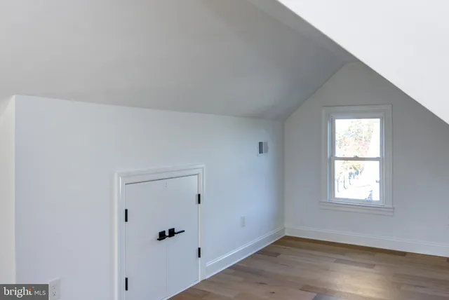 an empty room with wooden floor and window
