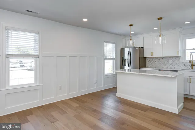 a large kitchen with stainless steel appliances granite countertop a stove a sink and a large window