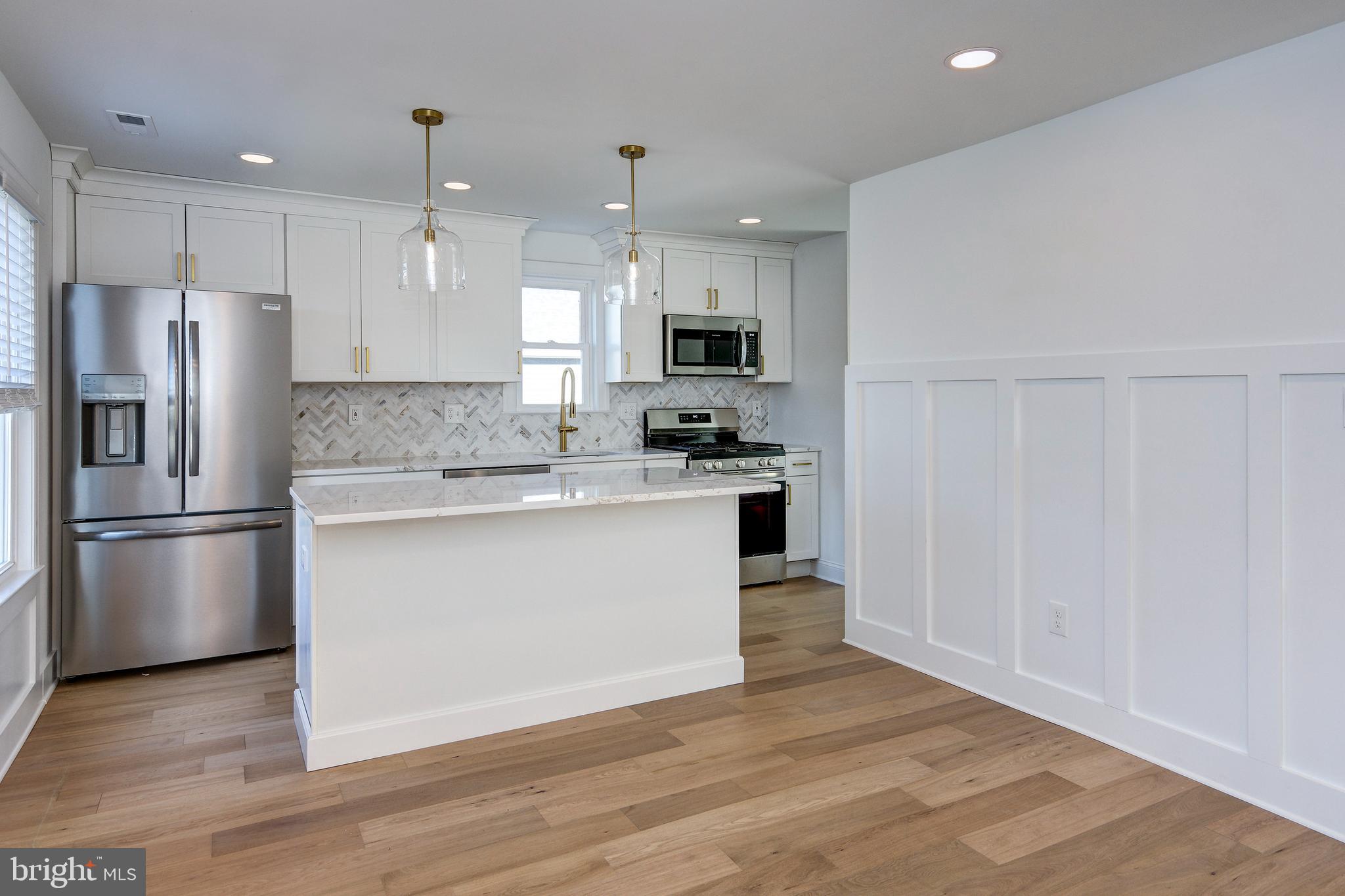 13 Wilkins Avenue Haddonfield, NJ 08033 - Photo 4 of 20 a kitchen with stainless steel appliances granite countertop a refrigerator a sink a stove a microwave and white cabinets with wooden floor