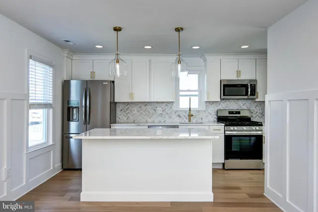 a kitchen with stainless steel appliances granite countertop a refrigerator a stove a sink and a microwave