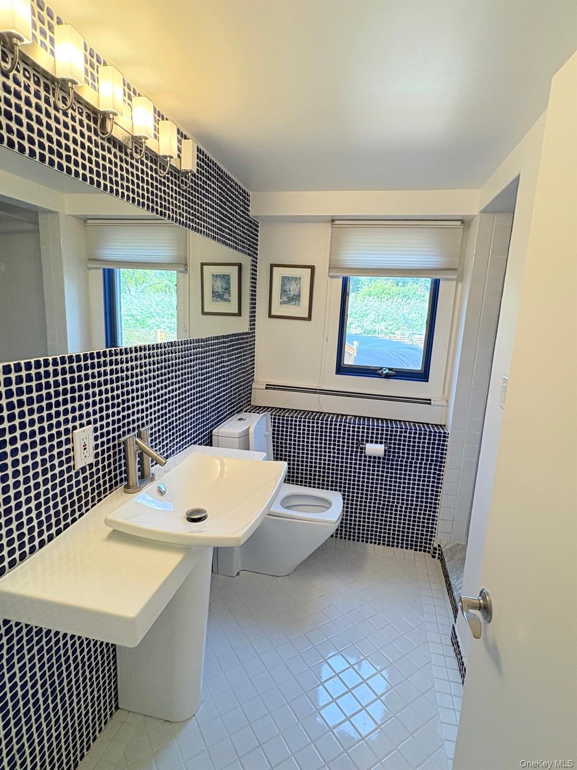 1 Dale Street Rye, NY 10580 - Photo 25 of 28 Lower-level full bath features blue & white checked tile, stylish pedestal sink with left & right vanity surfaces, white tiled floor and shower. Window faces backyard.