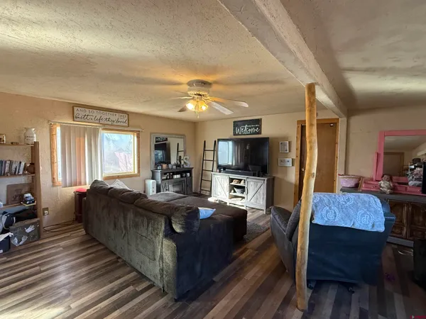 a living room with furniture a flat screen tv and kitchen view