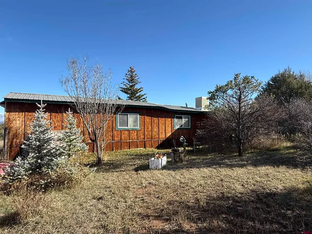 a backyard of a house with barbeque oven table and chairs