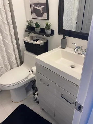 a bathroom with a toilet sink and mirror