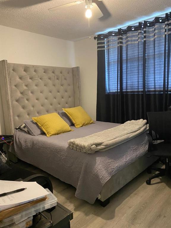 9091 Lime Bay Boulevard, Unit 304 Tamarac, FL 33321 - Photo 17 of 25 a bedroom with a bed and wooden floor