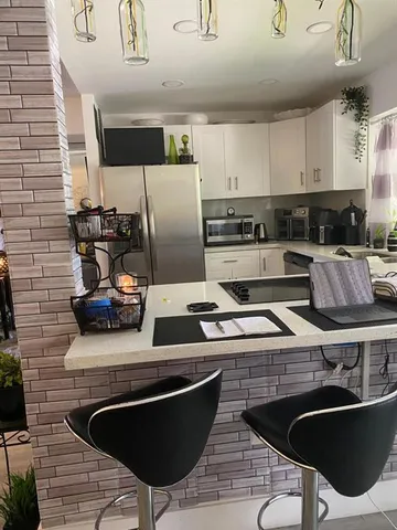 a kitchen with stainless steel appliances kitchen island granite countertop a sink and a stove