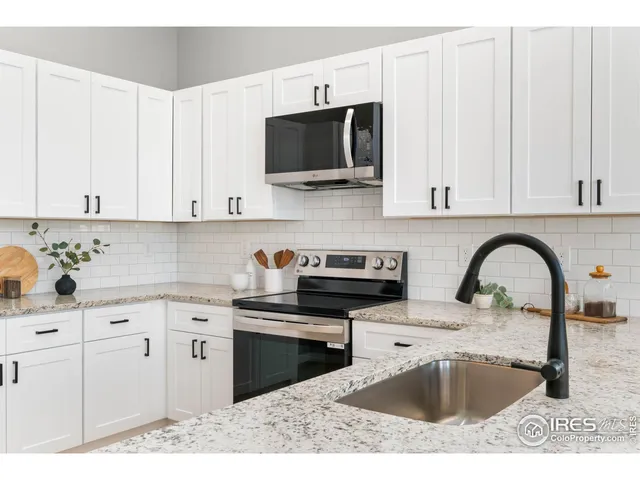 a kitchen with stainless steel appliances granite countertop a sink a stove a microwave and cabinets