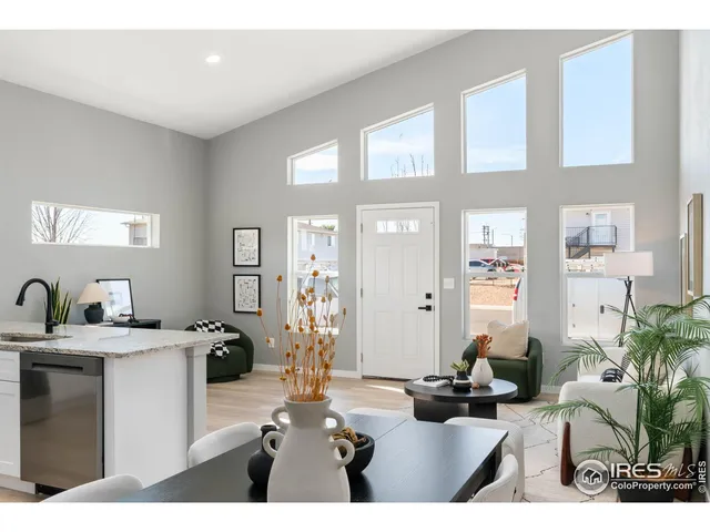 a living room with furniture a large window and potted plants