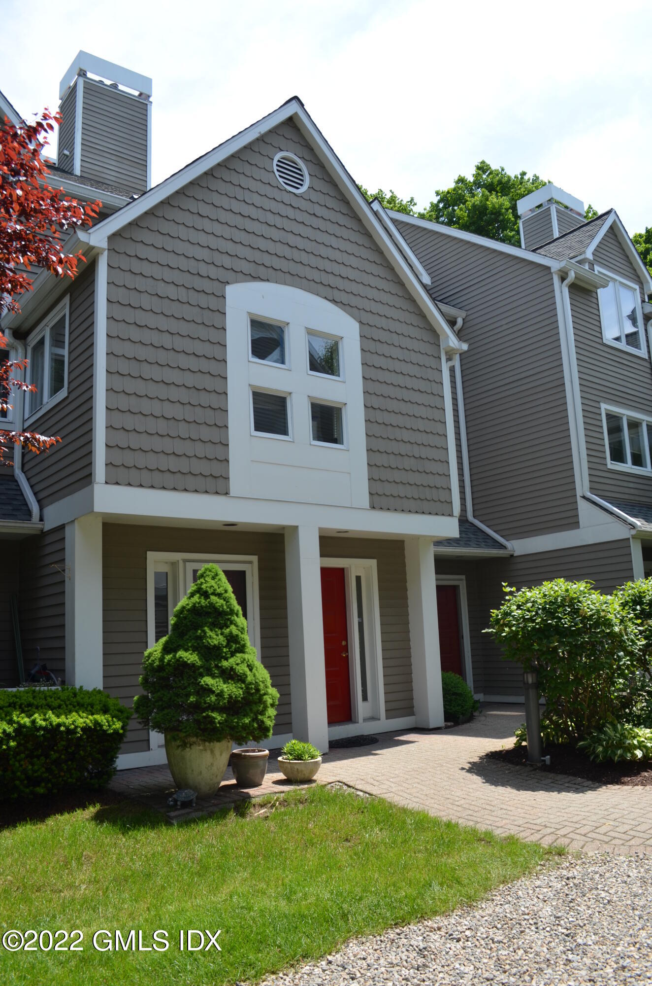 453 East Putnam Avenue, Unit 4H Cos Cob, CT 06807 - Photo 1 of 31 a front view of a house with a yard and potted plants