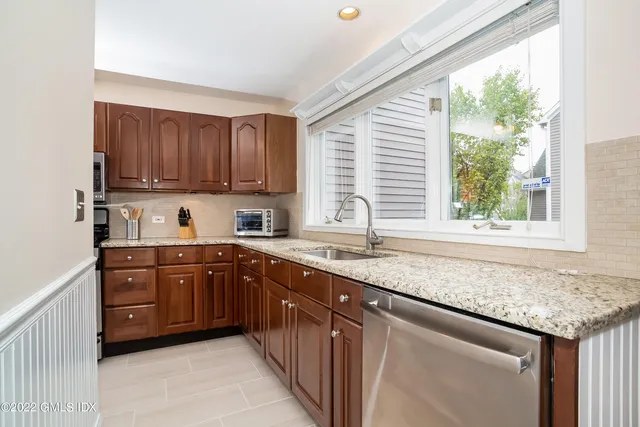 a kitchen with granite countertop cabinets sink and window