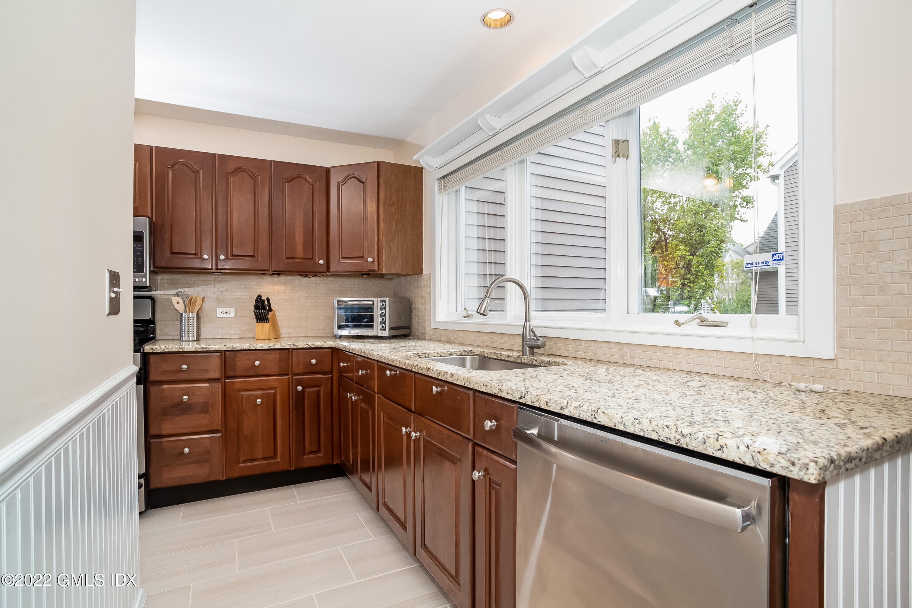 453 East Putnam Avenue, Unit 4H Cos Cob, CT 06807 - Photo 12 of 31 a kitchen with granite countertop cabinets sink and window