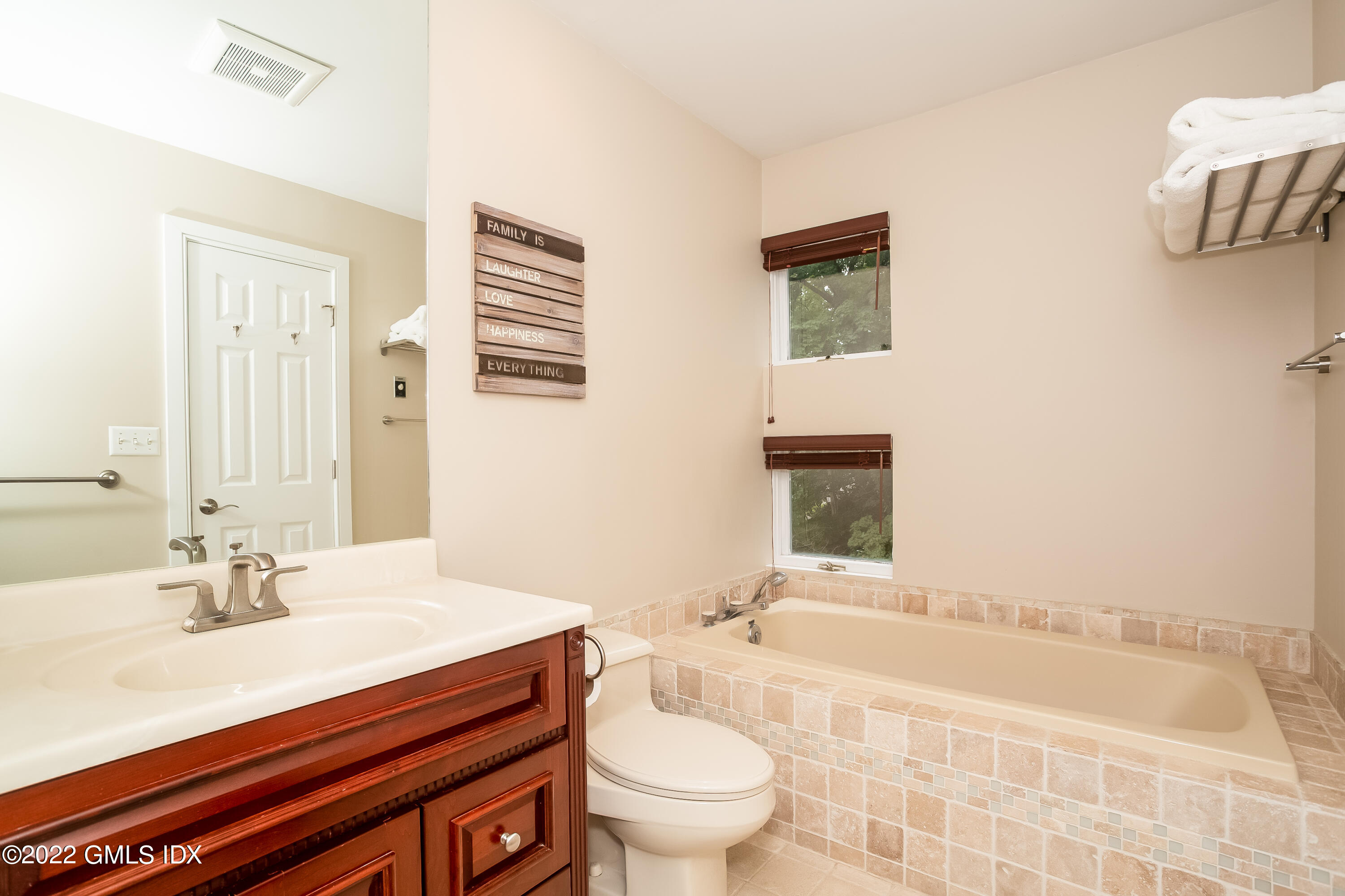 453 East Putnam Avenue, Unit 4H Cos Cob, CT 06807 - Photo 20 of 31 a bathroom with a sink a toilet and a large mirror