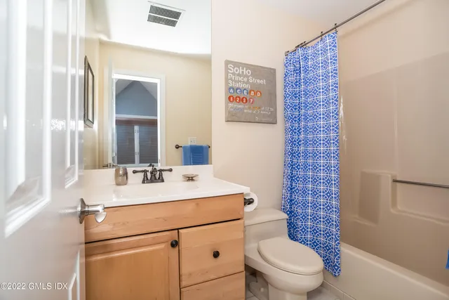 a bathroom with a sink a toilet a mirror and shower