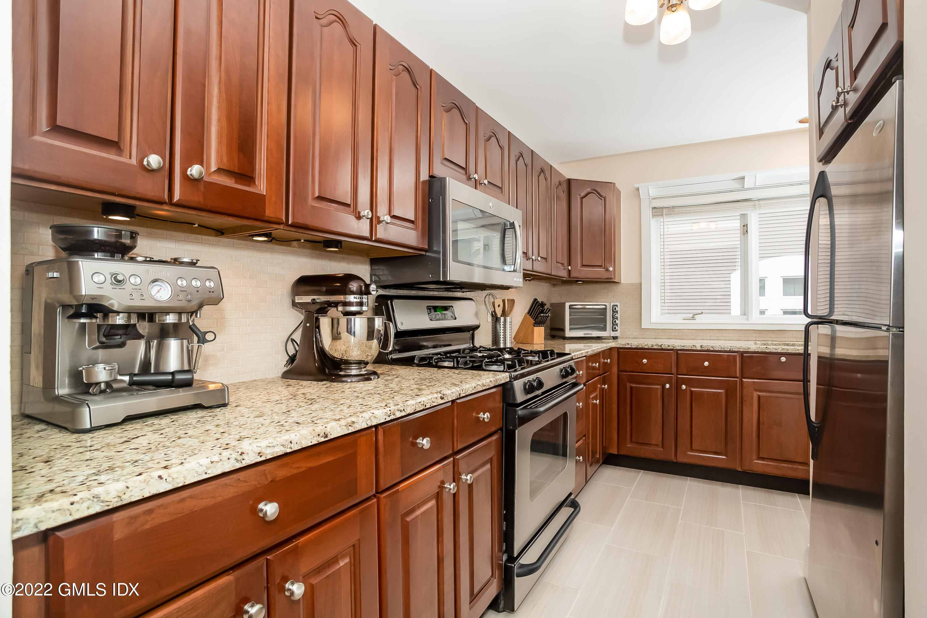 453 East Putnam Avenue, Unit 4H Cos Cob, CT 06807 - Photo 10 of 31 a kitchen with stainless steel appliances granite countertop a sink stove and refrigerator