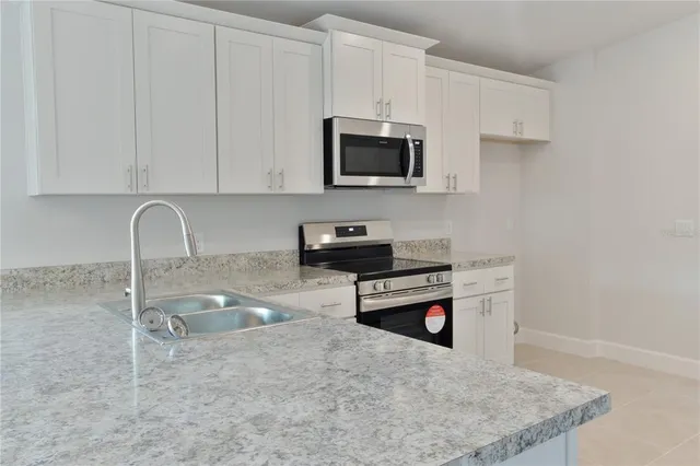 a kitchen with stainless steel appliances granite countertop a sink a stove and a microwave