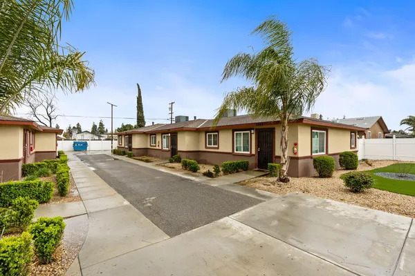 a front view of a house with a garden and tree