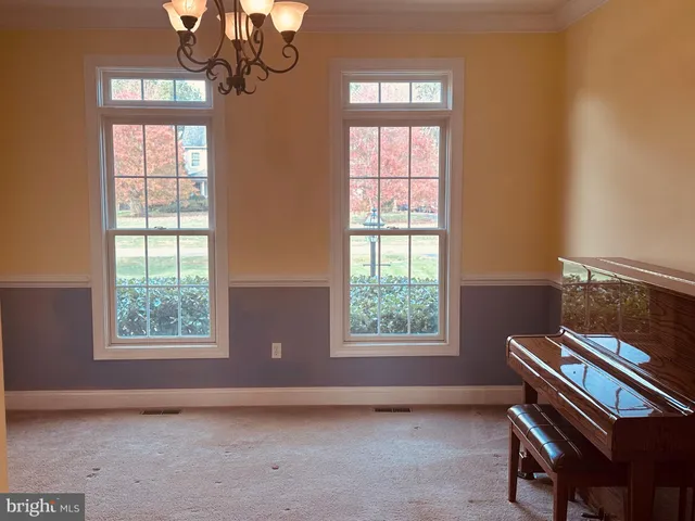 a living room with stainless steel appliances furniture a rug kitchen view and a large window