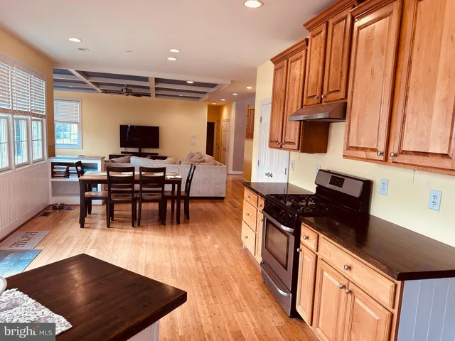 a kitchen with stainless steel appliances granite countertop a sink a stove and a wooden floors