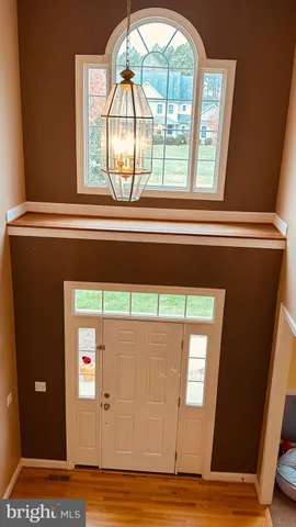 a living room with couches and kitchen view with wooden floor