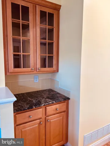 a open kitchen with granite countertop a sink and a stove top oven with wooden floor