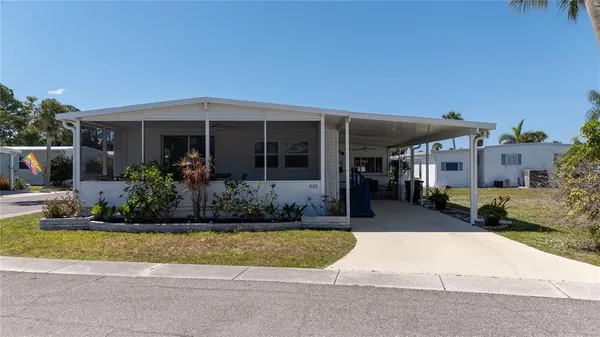 a front view of a house with a yard and potted plants