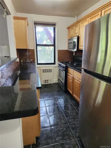 a kitchen with sink a refrigerator and a stove