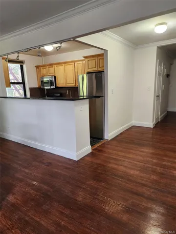 a view of a large room with wooden floor and windows