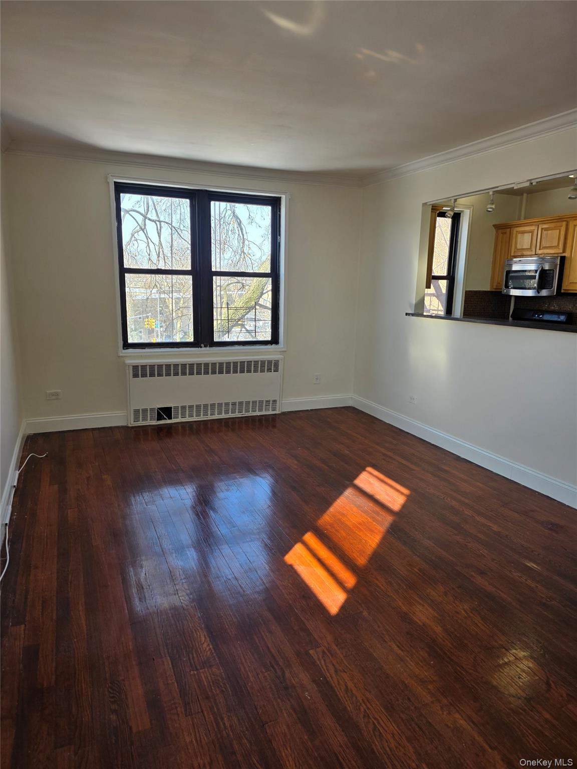 150-11 72nd Road Queens, NY 11367 - Photo 2 of 8 an empty room with wooden floor and windows