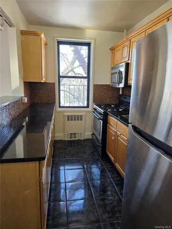 a kitchen with granite countertop a refrigerator stove and sink