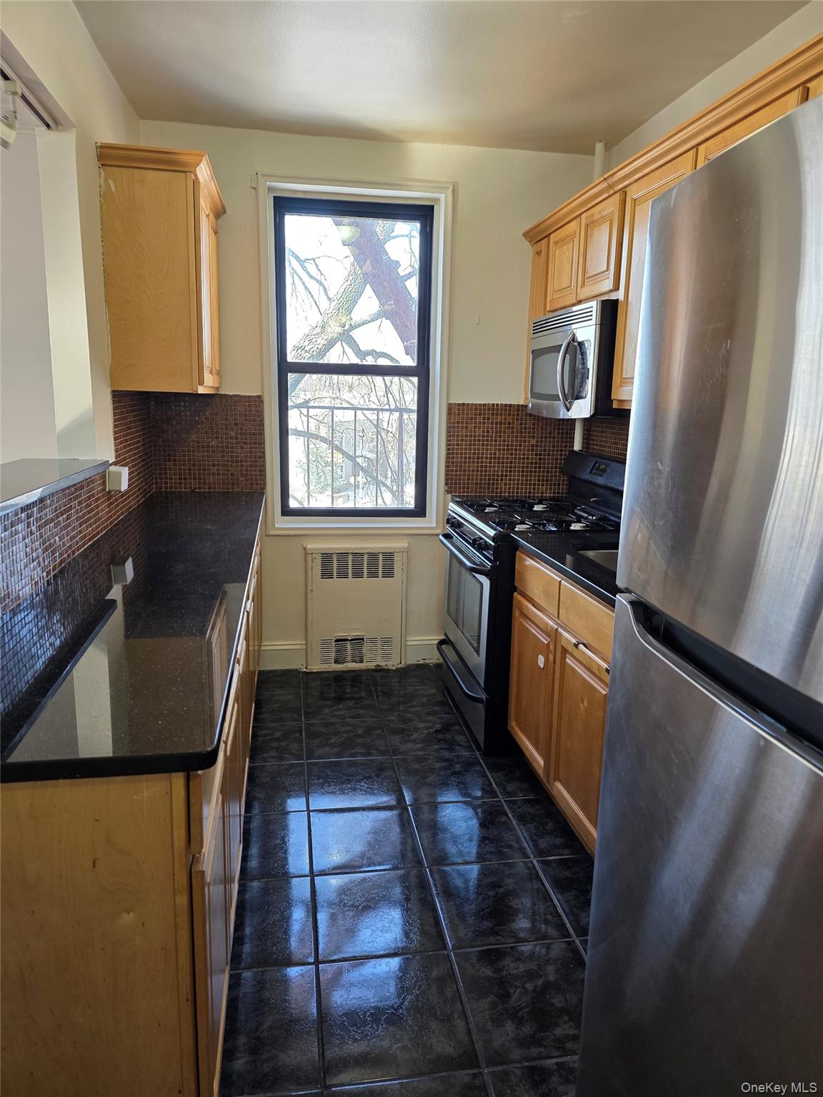 150-11 72nd Road Queens, NY 11367 - Photo 4 of 8 a kitchen with granite countertop a refrigerator stove and sink