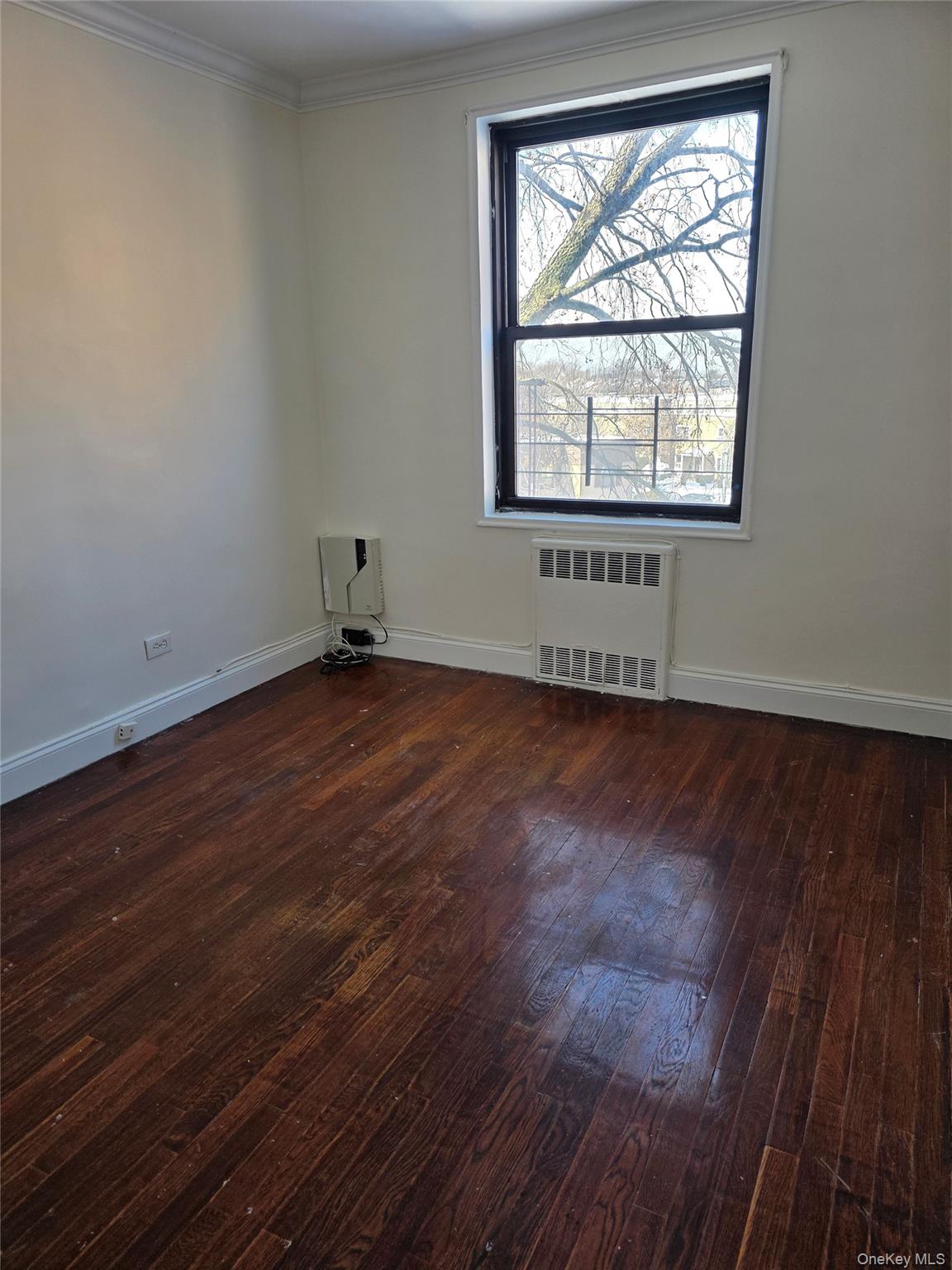150-11 72nd Road Queens, NY 11367 - Photo 6 of 8 an empty room with wooden floor and windows