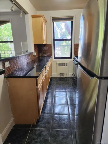 a view of a kitchen with wooden floor and a window
