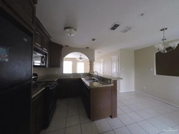 a kitchen with granite countertop a stove top oven and cabinets