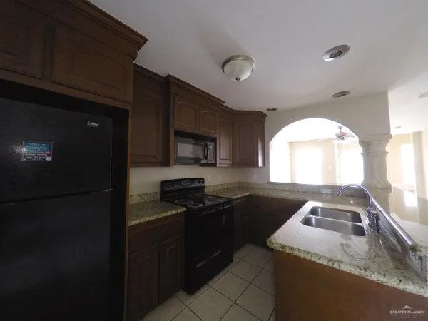 a kitchen with granite countertop stainless steel appliances a stove microwave and sink