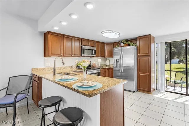 a kitchen with stainless steel appliances granite countertop a sink and a refrigerator